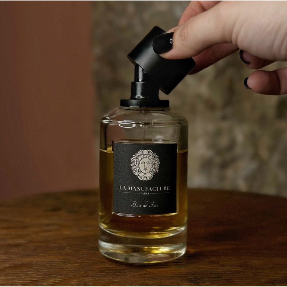 Au centre le flacon du parfum Bois de Feu en 100ml de la marque La Manufacture disponible chez ICI Concept Store mis en scène.