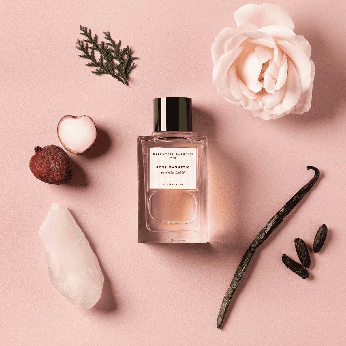 Le flacon de Rose Magnetic au centre entouré des arômes qui le composent : rose, santal, litchi