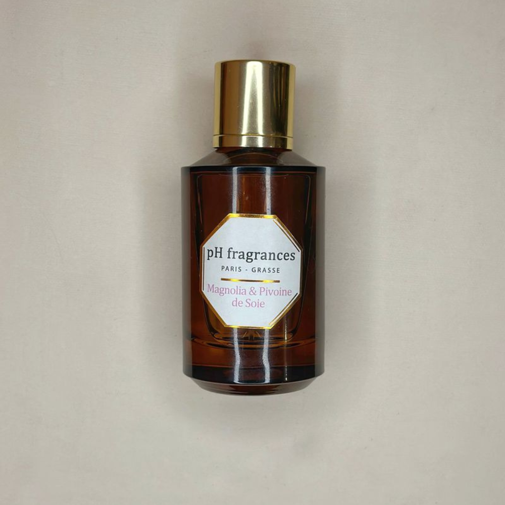 Au centre le flacon d'eau de parfum en 100ml de la marque pH Fragrances, disponible chez ICI Concept Store. 